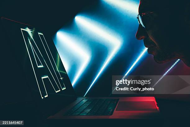 man using laptop with artificial intelligence screen in neon light. - screen replacement stock pictures, royalty-free photos & images