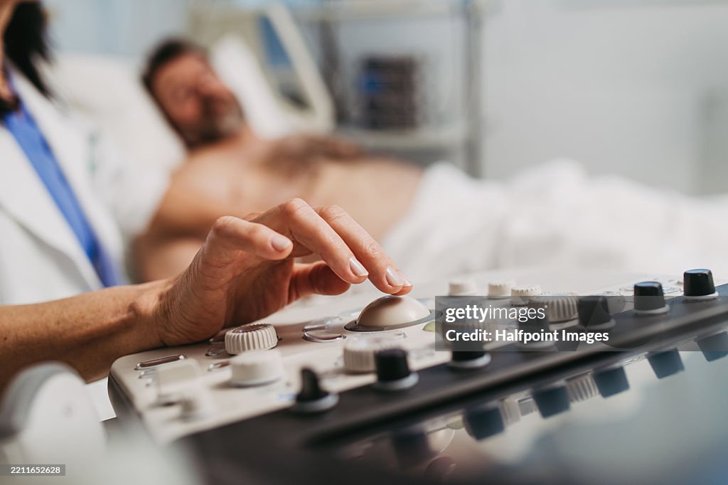 Close up of doctor performing an ultrasound on male patient's abdomen
