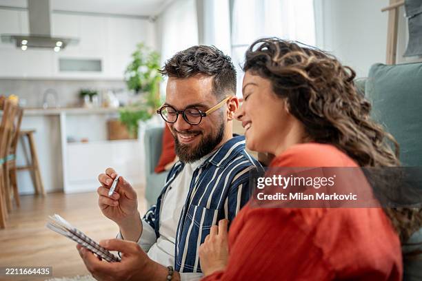 happy couple doing taxes and saving money at home - financial freedom stock pictures, royalty-free photos & images