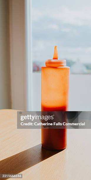 simple image of a bottle of ketchup in a diner - half full ketchup bottle stock pictures, royalty-free photos & images