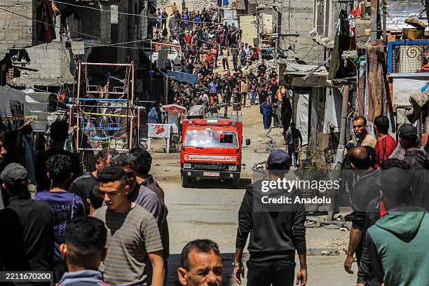Palestinians and civil defense teams conduct search and rescue operations in the damaged areas following the Israeli army's attack on settlements...