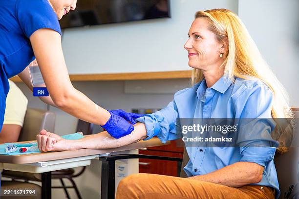 blonde frau phlebotomie blutabnahme im krankenhaus - blutspende stock-fotos und bilder
