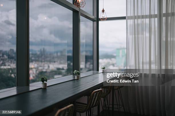 panoramic window view from modern co-sharing office with high chairs and hanging lights - tinted window stock pictures, royalty-free photos & images