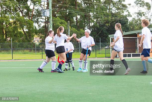 field hockey team celebrating scoring a goal - field hockey stock pictures, royalty-free photos & images