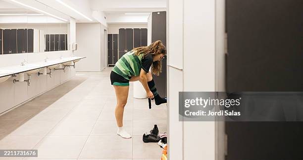 female athlete putting on socks in locker room getting ready - locker room stock pictures, royalty-free photos & images