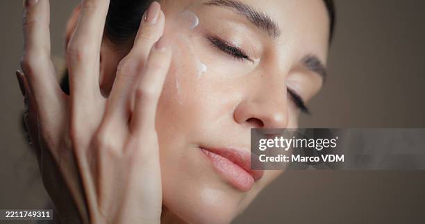 hautpflege, gesichtscreme und frau mit natürlicher, feuchtigkeitsspendender oder kollagener gesichtsbehandlung. schönheit, pflege und weibliche person mit dermatologischer routine mit lichtschutzfaktor, sonnencreme oder lotion nach studiohintergrund - gesichtscreme stock-fotos und bilder