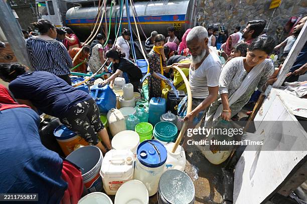 People collect water from a NDMC tanker on a hot summer day as water crisis continues, amid ongoing water crisis at Vivekanand Camp, Chanakyapuri, on...