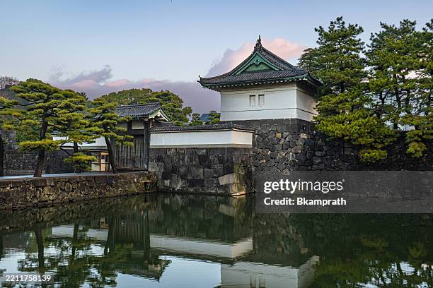 sunrise over the kikyō-mon gate and the imperial palace home to the emperor of japan in tokyo asia as seen from across the protective moat - keizerlijk paleis tokio stockfoto's en -beelden