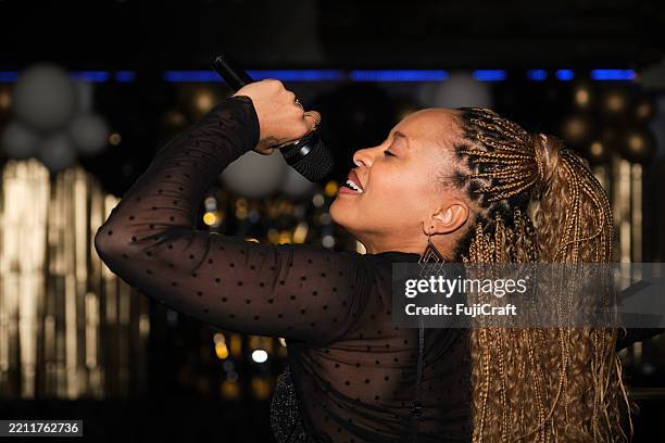 sängerin spielt live-musik mit mikrofon in einem nachtclub - sängerin stock-fotos und bilder