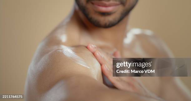 crema hidratante, cuidado de la piel y hombre con loción en estudio para la rutina de aseo, limpieza o hidratación. dermatología, crema corporal y primer plano de persona masculina con protector solar para protección por fondo marrón. - crema corporal fotografías e imágenes de stock