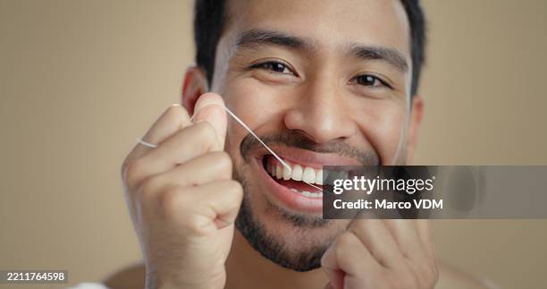 man, portrait and dental floss with smile in studio for cleaning mouth, oral care or wellness by background. person, model and benefits for health with hygiene, happy and routine for teeth - bad breath stock pictures, royalty-free photos & images