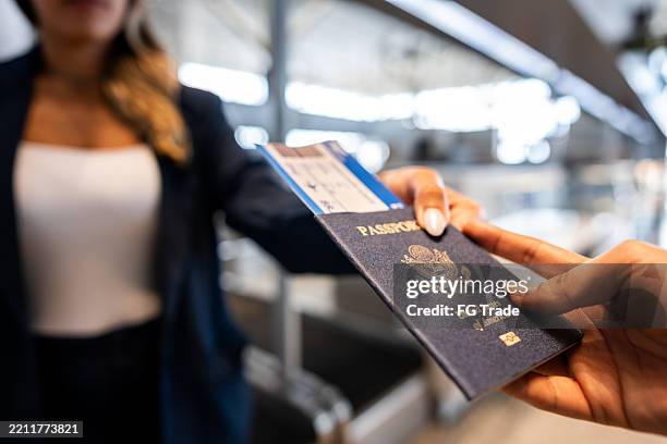 mujer dando su pasaporte a una azafata en el aeropuerto - emigración e inmigración fotografías e imágenes de stock