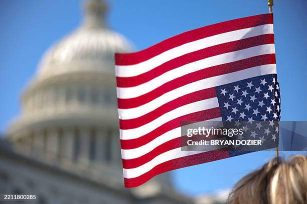 Demonstrator holds an upside-down U.S. Flag during a sit-in protest against a Republican budget plan on the House steps of the U.S. Capitol in...