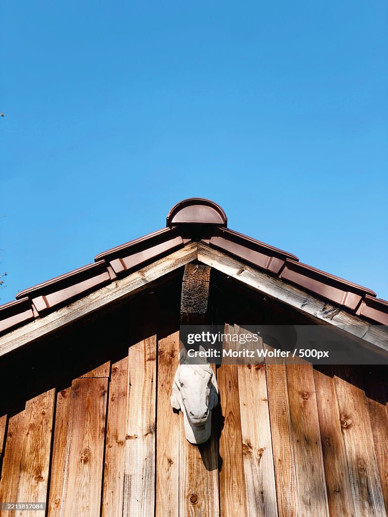 Wooden rooftop with an horse statue and skyl