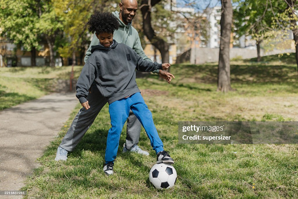 Kick Together Father And Son Kick A Soccer Ball Together High-Res Stock Photo - Getty ...