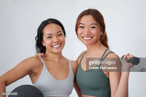 two women engaged in fitness activities together in a bright space - hand weight stock pictures, royalty-free photos & images