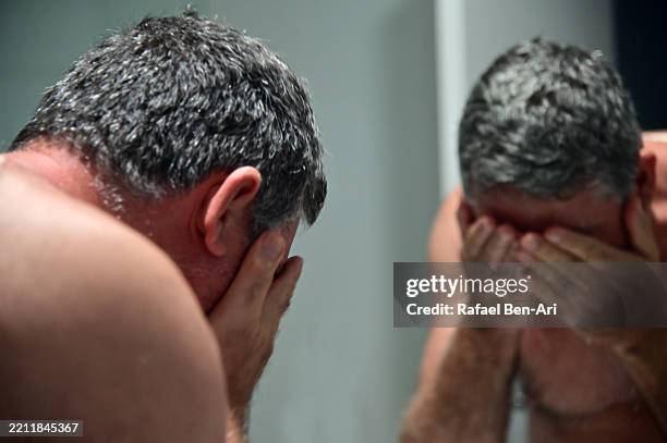 upset mature adult man reflection in mirror - midlife crisis stock pictures, royalty-free photos & images