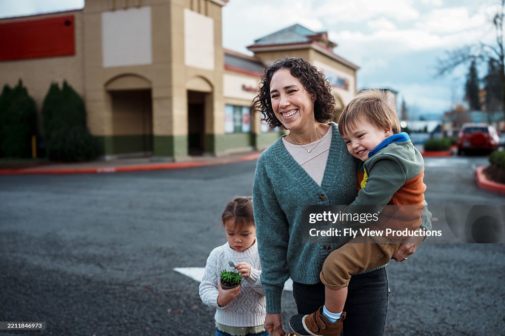 Famiglia felice che cammina nel parcheggio del negozio di alimentari