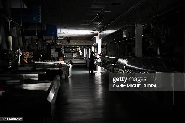 Man and a child walk through a local market during a massive power cut in Vigo, northwestern Spain, on April 28, 2025. A massive power cut affects...