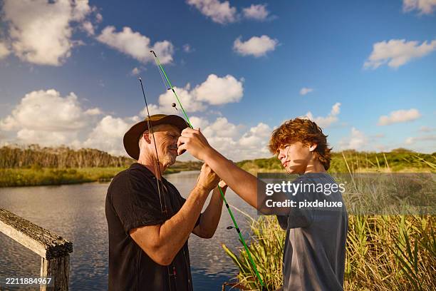 father and son untangling fishing rods by australian lake - fishing stock pictures, royalty-free photos & images