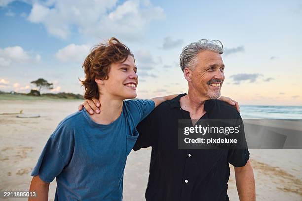 father and son walking on the beach at sunset in australia - golden hour stock pictures, royalty-free photos & images