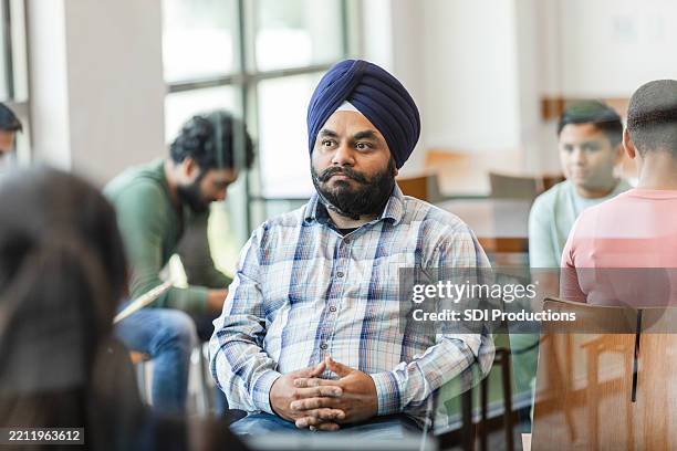 confident man in group therapy session, using laptop - turban stock pictures, royalty-free photos & images