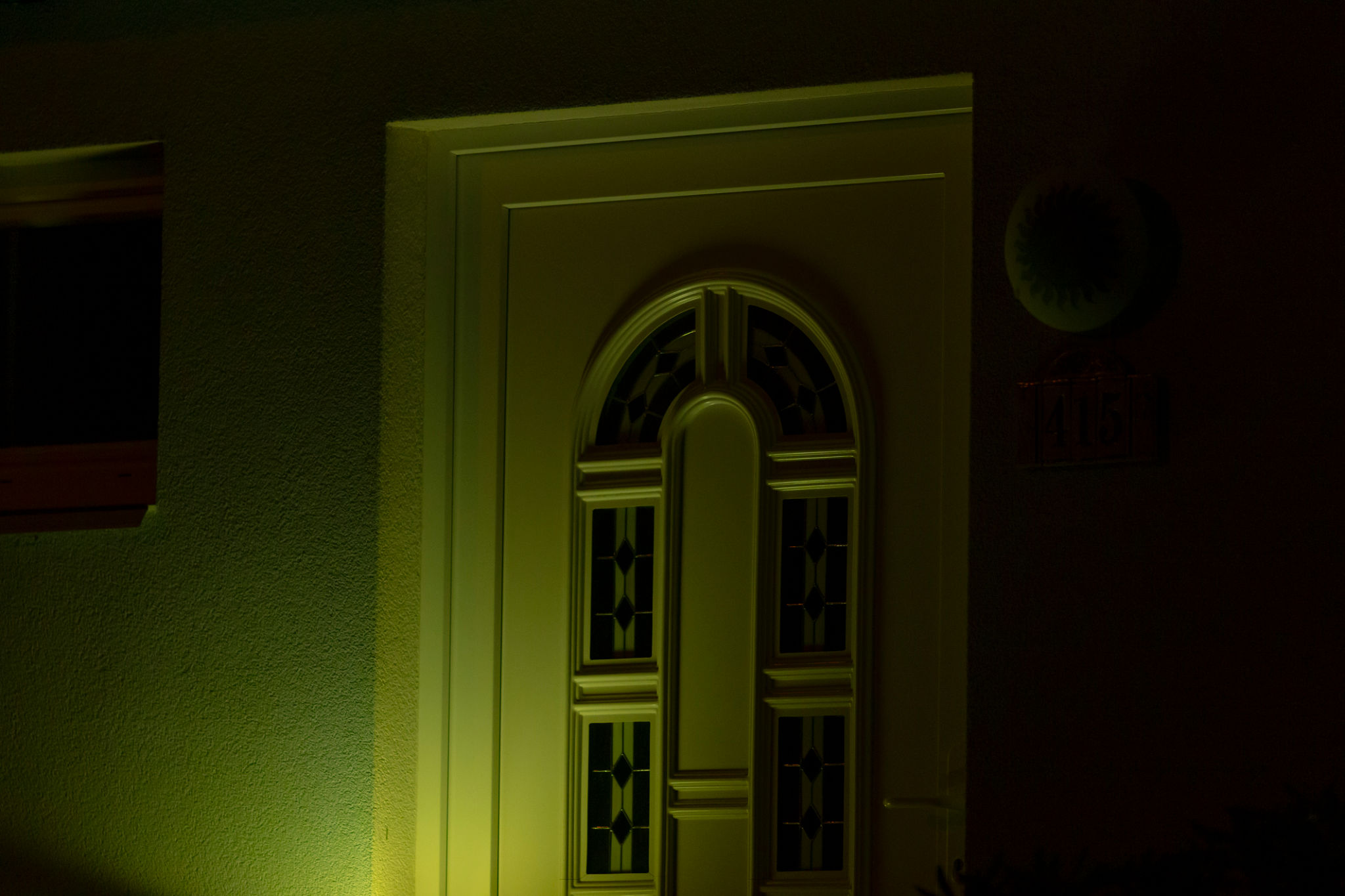 The beautifully illuminated front door at night features a unique design The beautifully illuminated front door at night features a unique design