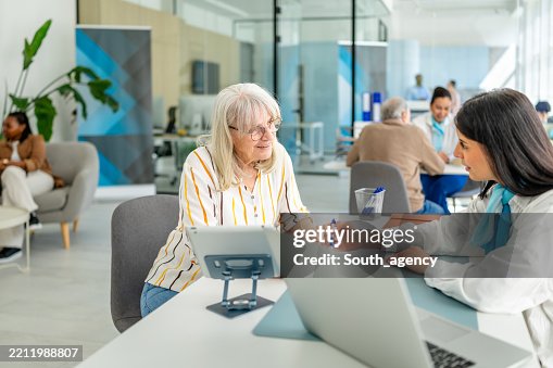 Financial advisor discusses banking options with a senior client in a modern bank office setting Financial advisor discusses banking options with a senior client in a modern bank office setting