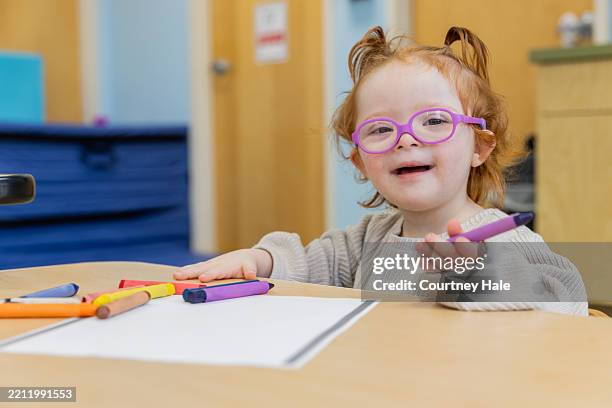 young girl with down syndrome engaged in art project - preschool student stock pictures, royalty-free photos & images