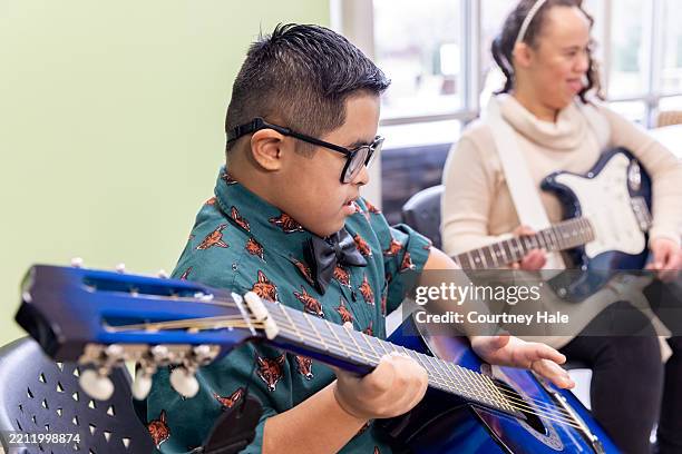 tiempo de práctica de guitarra para jóvenes estudiantes - girl playing bass guitar fotografías e imágenes de stock