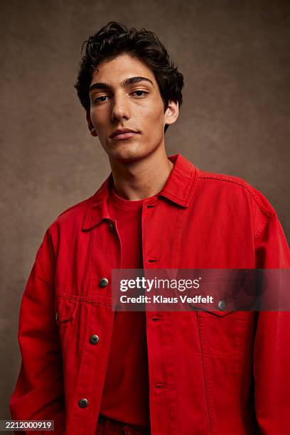 confident young man wearing red jacket - attitude stock pictures, royalty-free photos & images