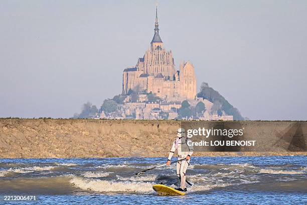 Surfer wearing a stormtrooper costume rides the tidal bore on a paddle board, at the Mont Saint-Michel Bay, northwestern France, on April 29, 2025.