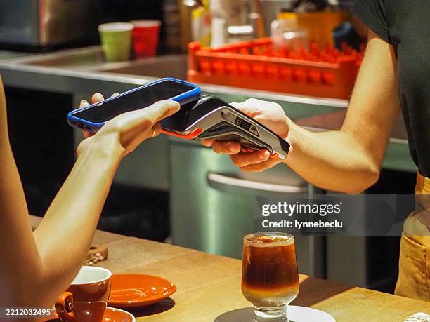 contactless payment in city cafe - aboriginal and torres strait islander commission stock pictures, royalty-free photos & images