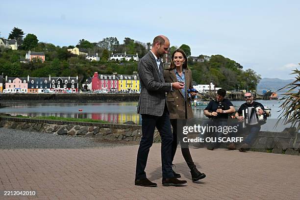 Britain's Prince William, Prince of Wales and Britain's Catherine, Princess of Wales walk along the seafront after visiting stall holders at an...