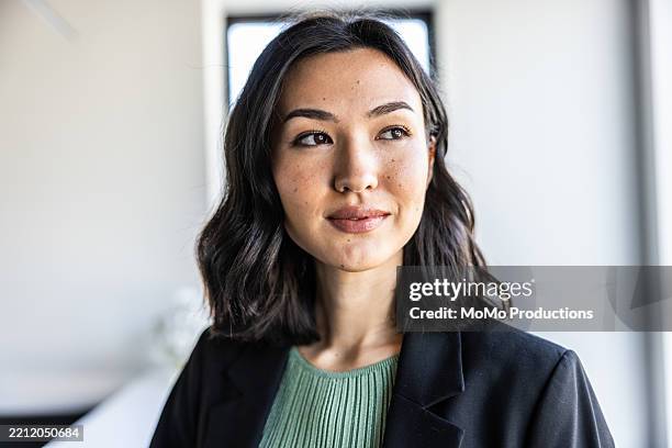 portrait of young businesswoman in modern office lobby - personnes féminines photos et images de collection