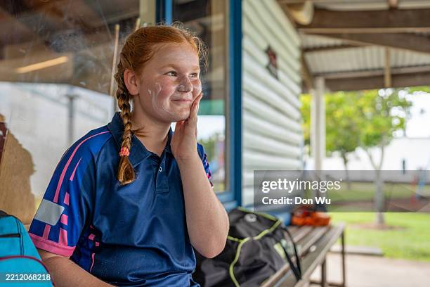 young cricket player rubbing in sunscreen - sun cream stock pictures, royalty-free photos & images
