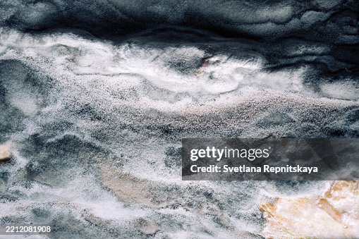 Efflorescence creating stunning salt deposit patterns on dark rock surface Efflorescence creating stunning salt deposit patterns on dark rock surface