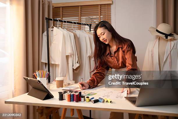 young asian woman designers are working at home. attractive stylish beauty women in process of creating new clothes collection. designers and editors are designing clothes at room - fashion stylist foto e immagini stock