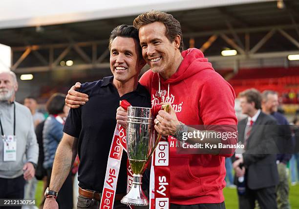 Rob McElhenney and Ryan Reynolds, co-owners of Wrexham AFC, pose for a photo with the trophy following the club's promotion to the Sky Bet...