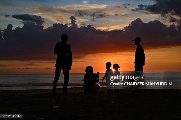 People enjoy the sunset at a beach in Lhoknga, Indonesia's Aceh province on April 30, 2025.