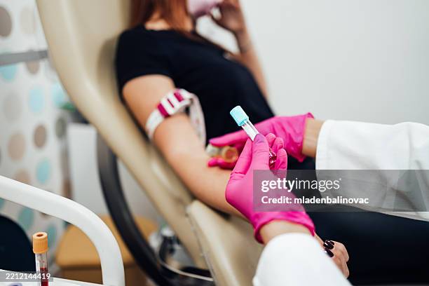 enfermera recogiendo muestras de sangre de una paciente femenina en una clínica médica - donante de sangre fotografías e imágenes de stock