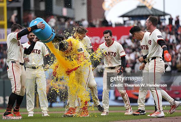 Patrick Bailey of the San Francisco Giants is soaked with gatorade by a teammate after Bailey hit a pinch hit walk-off RBI single in the bottom of...