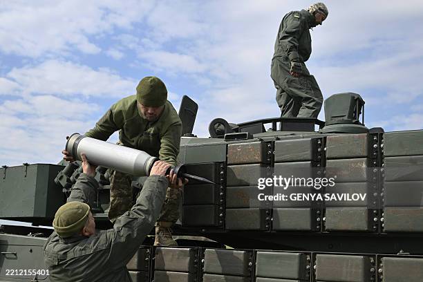 Ukrainian tank crew of the 33rd Separate Mechanized Brigade load tank ammunition onto a Leopard 2A4 tank during a field training exercise at an...