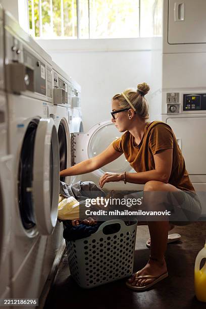a girl using laundromat - imperfection stock pictures, royalty-free photos & images