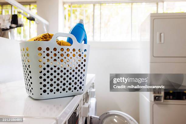 wäsche in einer tasche mit waschmittel im waschsalon - weidenkätzchen stock-fotos und bilder