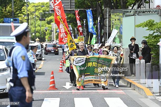 People take part to the 96th May Day rally to mark the International Workers Day on May 1, 2025 in Tokyo, Japan. Holding placards and signs, people...