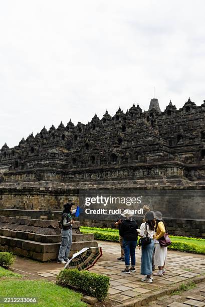 female tour guide showing and explaining about borobudur temple to tourist group - unesco organised group stock pictures, royalty-free photos & images