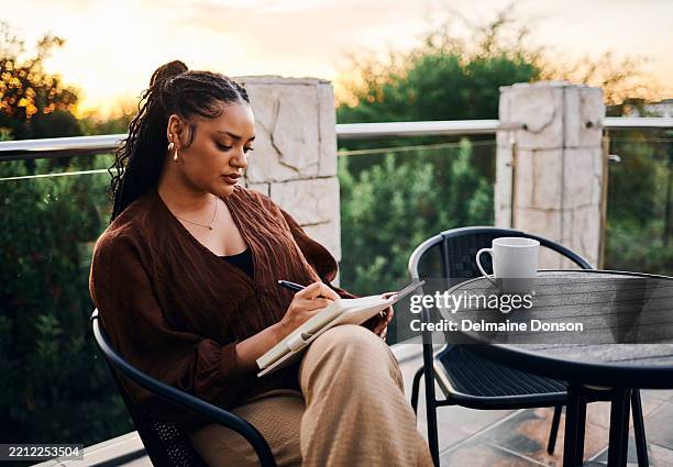serene woman journaling outdoors at sunset - dagbok bildbanksfoton och bilder