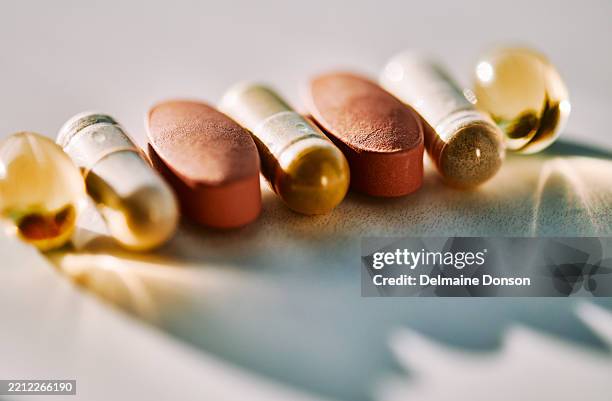 pillole e capsule assortite colorate alla luce del sole - integratore vitaminico foto e immagini stock