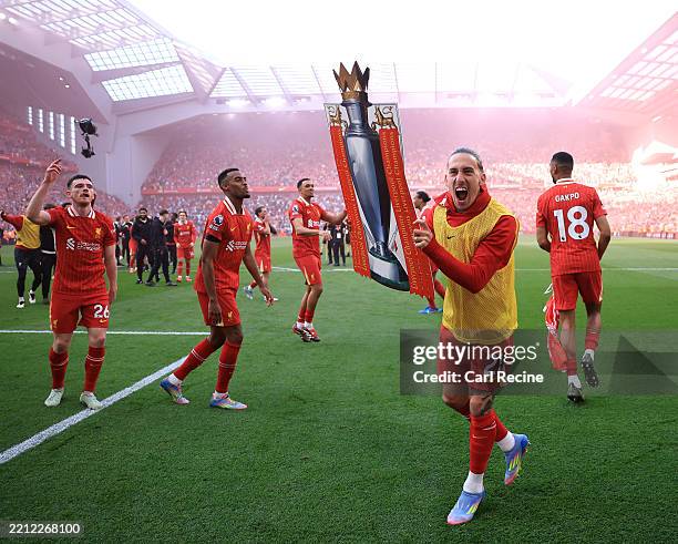 Kostas Tsimikas of Liverpool celebrate with a card board cut out of the Premier League trophy after the teams victory and confirmation of winning the...